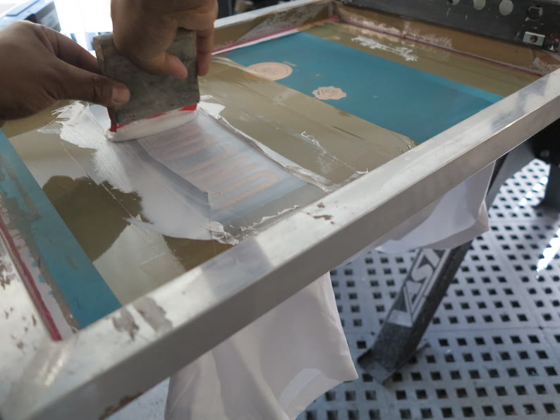 Encrage d’un écran de sérigraphie avant tirage à l’atelier