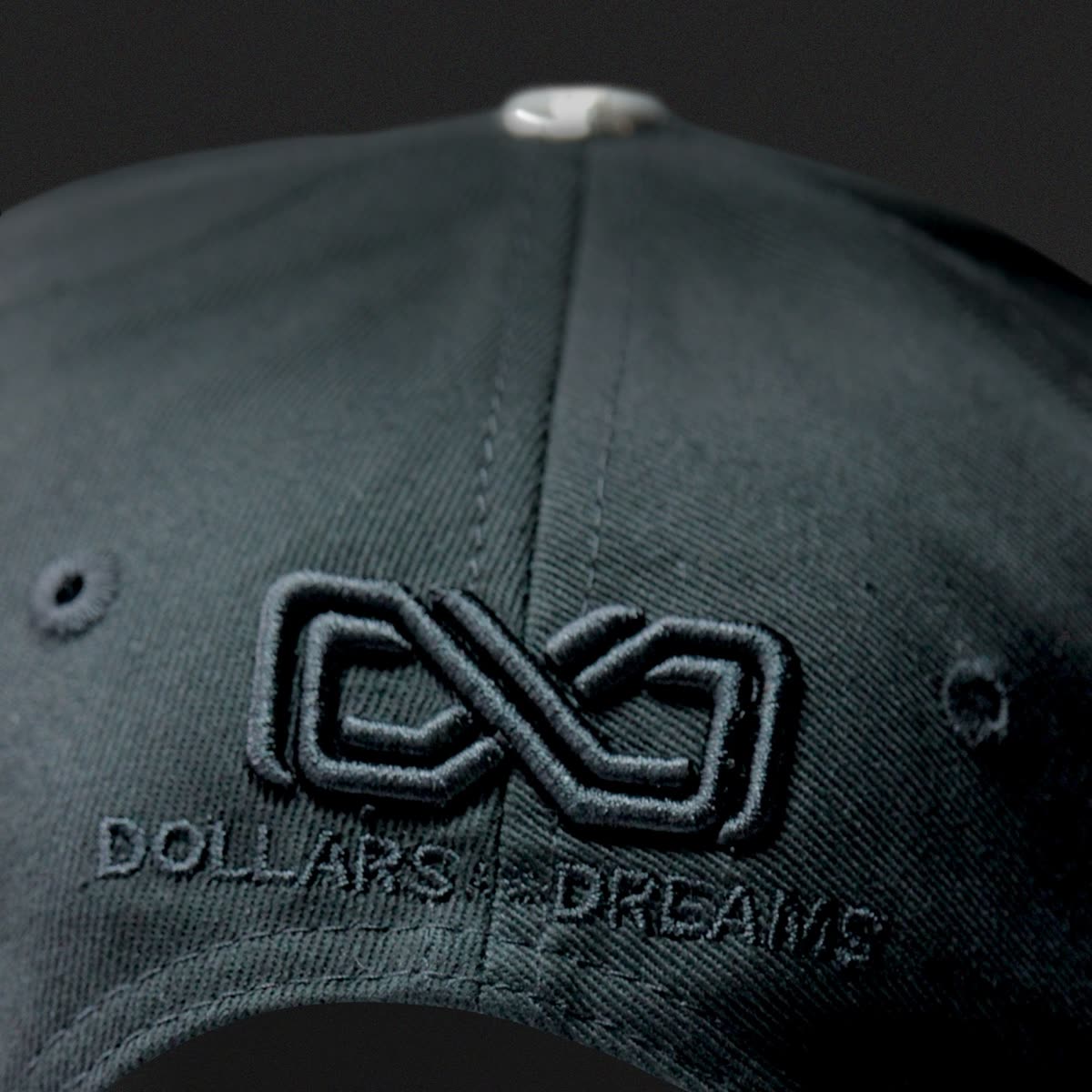 Broderie ton sur ton du monogramme Dollars and Dreams sur une casquette noire