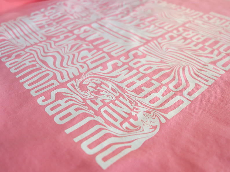 Motif typographique sérigraphié en blanc sur un t-shirt corail