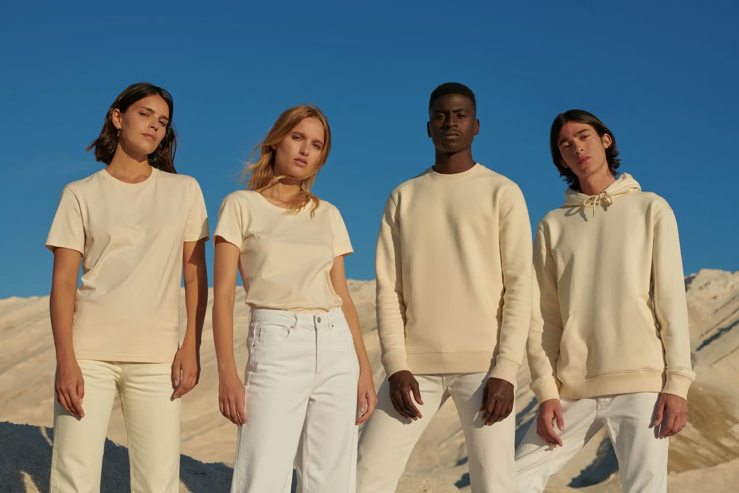 Collection de basiques en coton écru portée par quatre mannequins